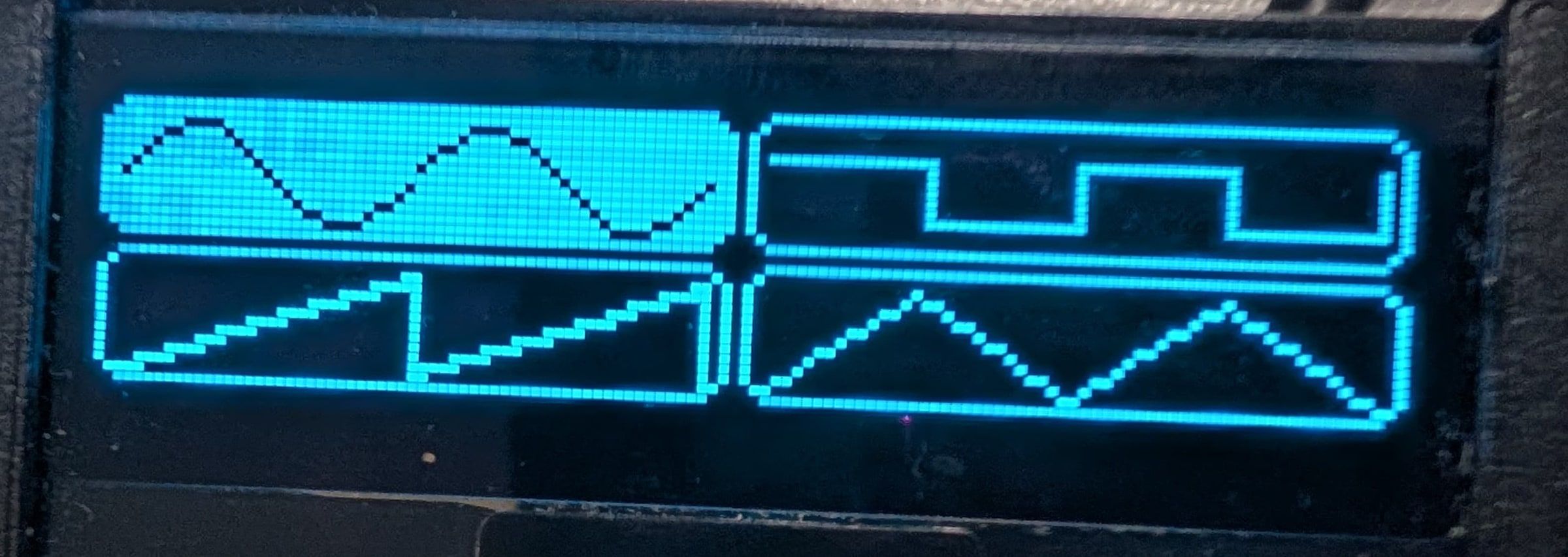 The OLED showing a two-by-two grid of waveform icons: sine, square, sawtooth and triangle, with sine selected.